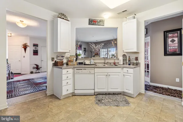 a kitchen with granite countertop a sink cabinets and window