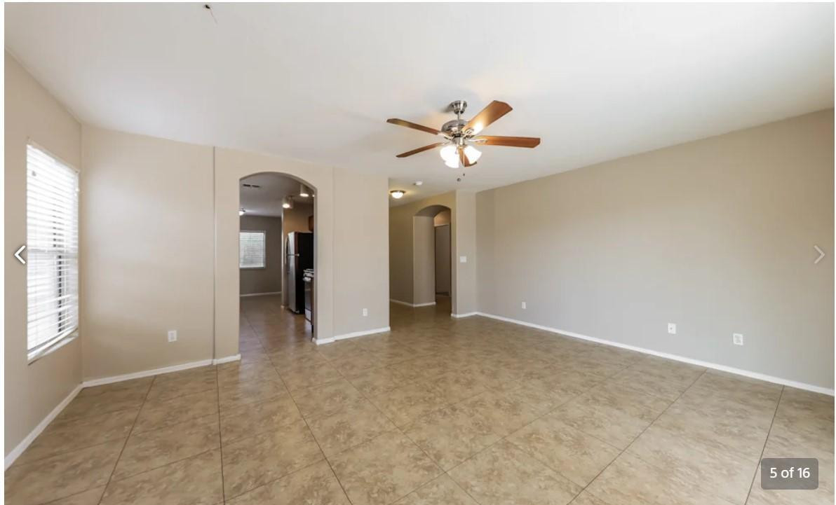 12563 West Charter Oak Road El Mirage, AZ 85335 - Photo 5 of 16 an empty room with chandelier fan and windows