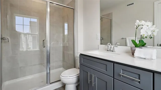 a bathroom with a granite countertop sink toilet and shower