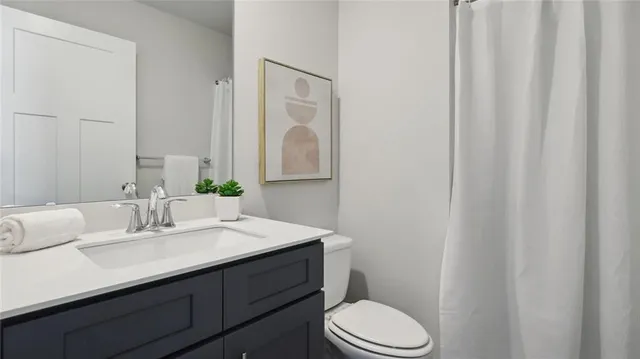 a bathroom with a sink vanity mirror and toilet