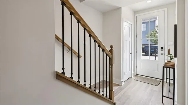 a view of a hallway with wooden floor and staircase