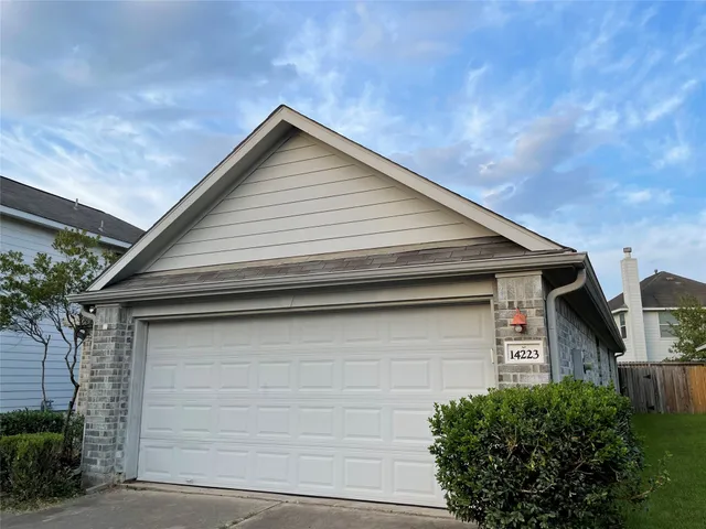 an empty room with windows fireplace and wooden floor
