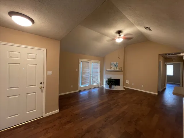 a view of a livingroom with a fireplace wooden floor and a chandelier fan
