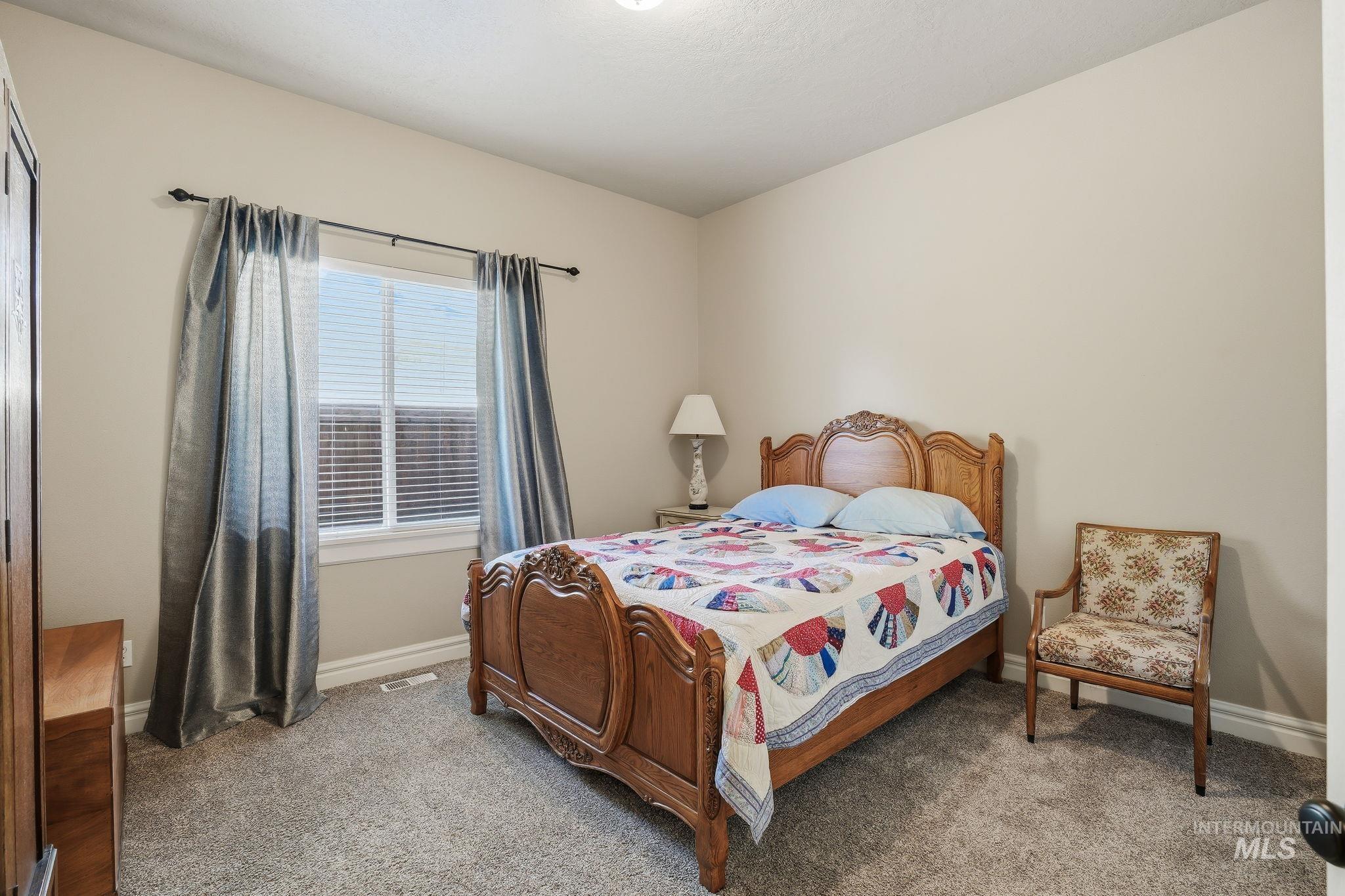 3969 North Hollymount Way Meridian, ID 83646 - Photo 28 of 47 Bedroom featuring a window with blinds, light-toned walls, and grey carpeting