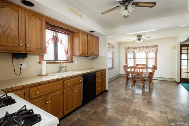 a kitchen with stainless steel appliances granite countertop a stove top oven a sink a dining table and chairs with wooden floor