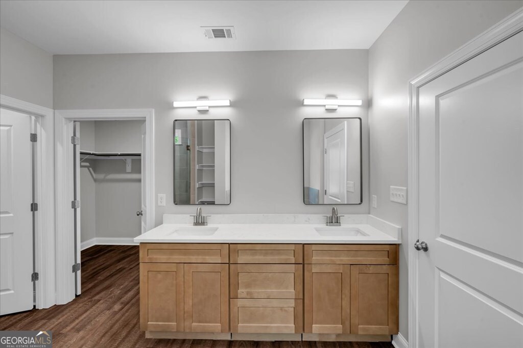 2767 Claxton Dairy Road Dublin, GA 31021 - Photo 29 of 51 a bathroom with a double vanity sink a mirror and shower