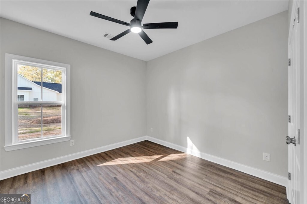 2767 Claxton Dairy Road Dublin, GA 31021 - Photo 32 of 51 wooden floor in an empty room with a window