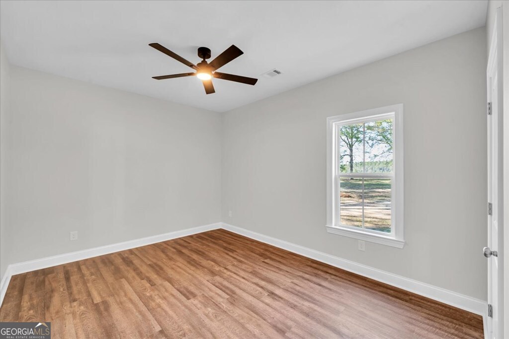 2767 Claxton Dairy Road Dublin, GA 31021 - Photo 36 of 51 a view of empty room with wooden floor and fan