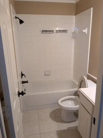 a white toilet sitting next to a bath tub