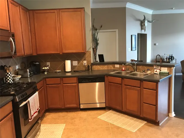 a kitchen with granite countertop a sink stove and cabinets