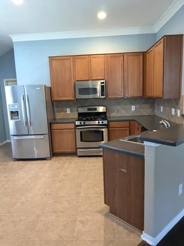 a kitchen with granite countertop a refrigerator and a stove top oven