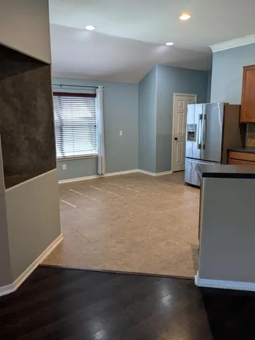 an empty room with wooden floor cabinet and windows