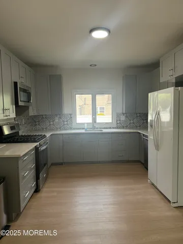 a kitchen with a refrigerator and a stove top oven