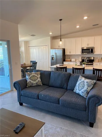 a living room with furniture kitchen and a table