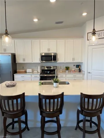 a kitchen with kitchen island granite countertop a dining table and chairs