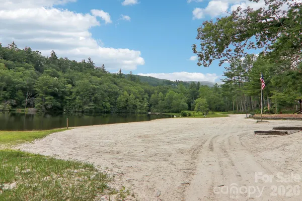 a backyard of a house with lots of green space and lake view