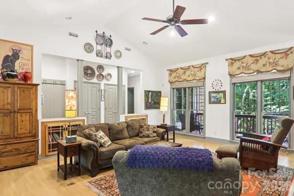 a living room with furniture fireplace and large windows