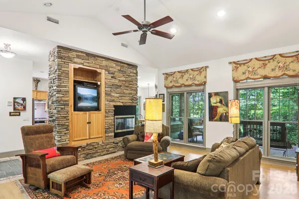 a living room with furniture ceiling fan and a large window