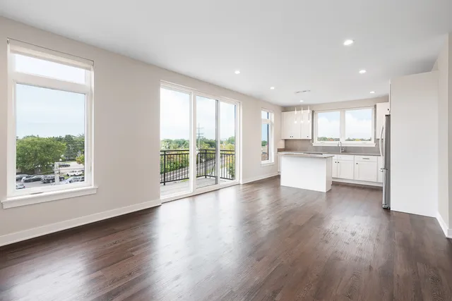 a kitchen with wooden floors and white stainless steel appliances