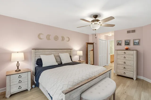 a spacious bedroom with a bed and a chandelier