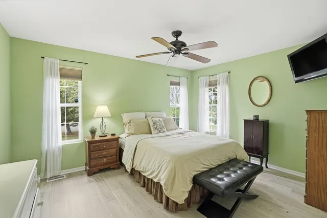 a bedroom with a bed a mirror and a window