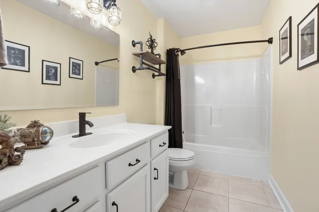 a bathroom with a tub shower sink and mirror
