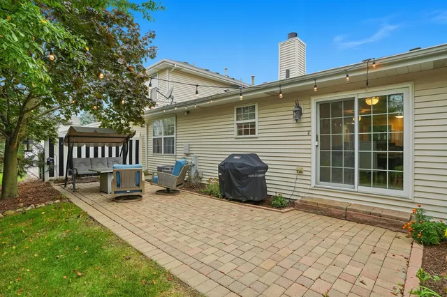 a view of a house with a patio and a yard