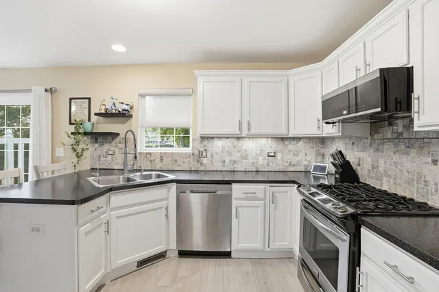 a kitchen with white cabinets and appliances