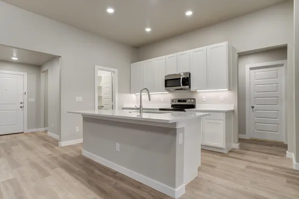 a kitchen with kitchen island granite countertop a sink stainless steel appliances and cabinets
