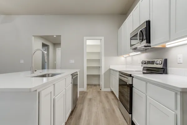 a kitchen with stainless steel appliances a stove sink microwave and refrigerator
