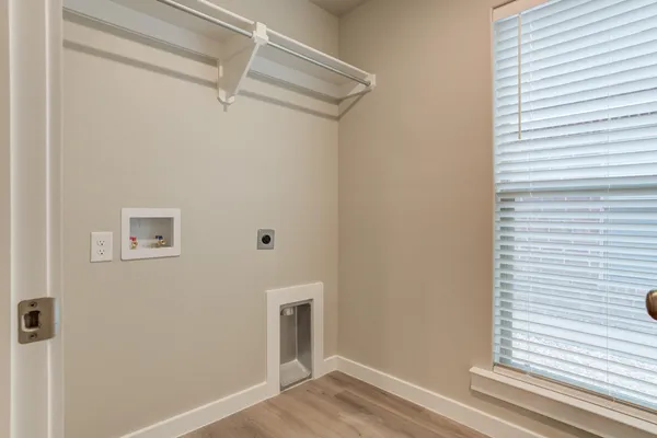a view of a hallway with wooden floor and a window