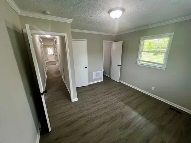an empty room with wooden floor and entrance
