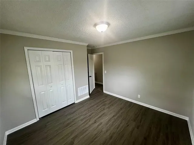 an empty room with wooden floor and closet area