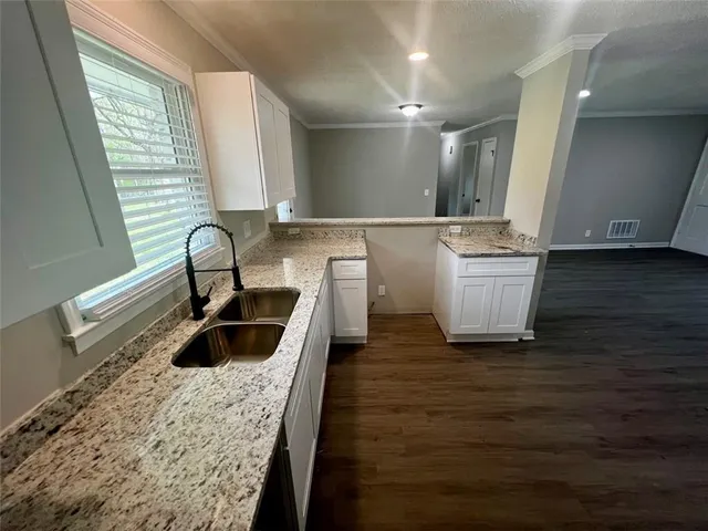 a kitchen with a sink and a wooden floor