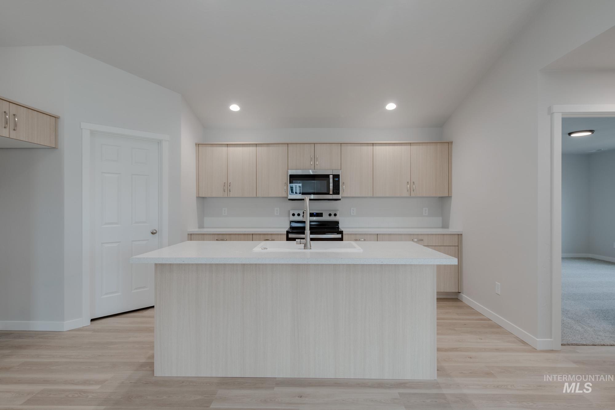 3090 South Maple Rnch Way Nampa, ID 83686 - Photo 3 of 22 Kitchen featuring light brown cabinets, light countertops, stainless steel appliances, a kitchen island with sink, and light wood-style floors