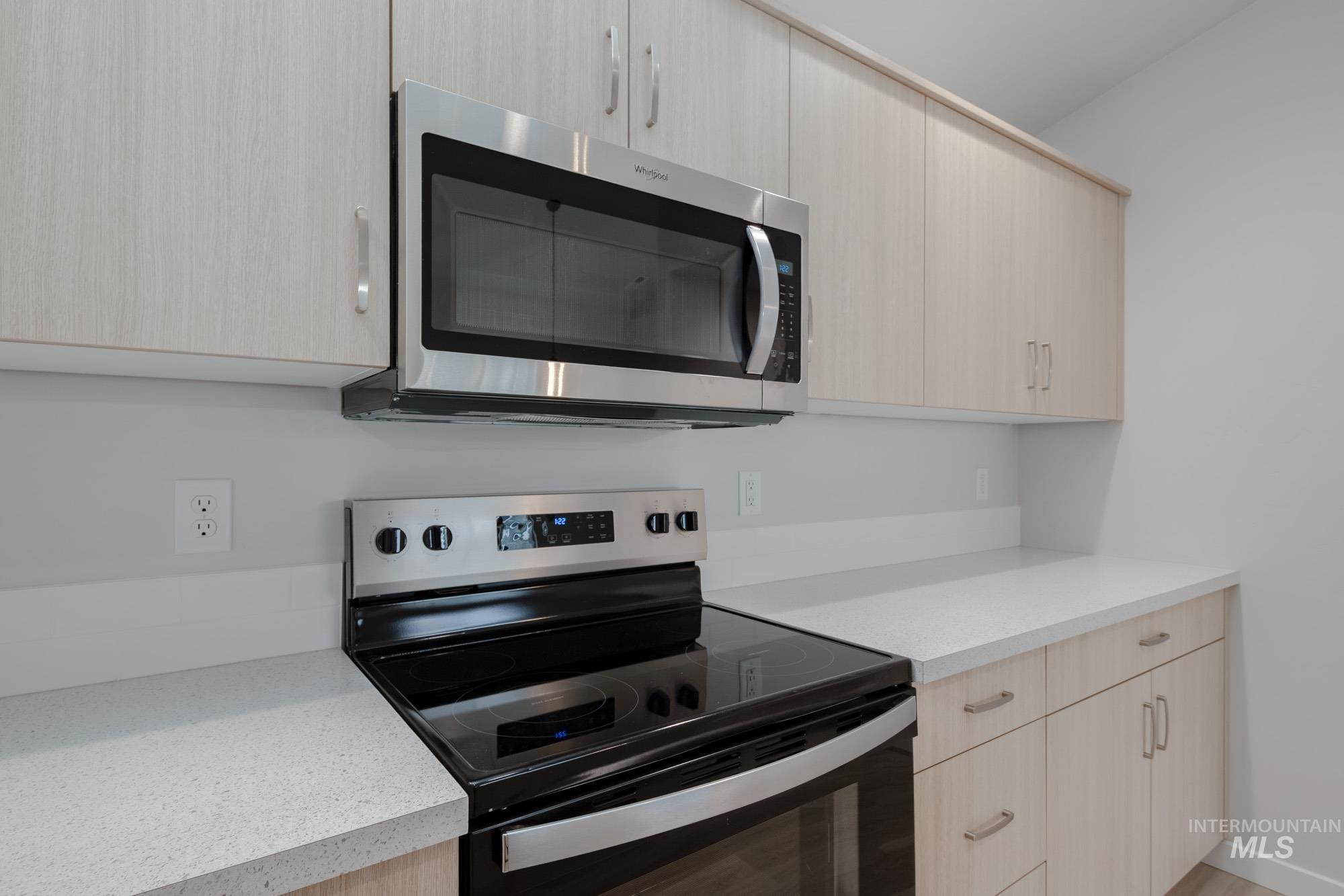 3090 South Maple Rnch Way Nampa, ID 83686 - Photo 6 of 22 Kitchen featuring stainless steel appliances, light brown cabinetry, modern cabinets, and light stone countertops