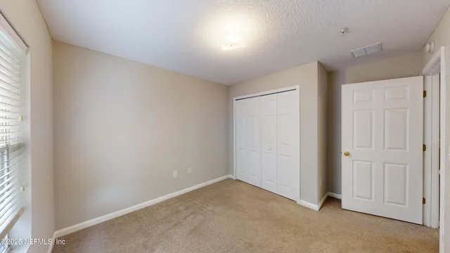 an empty room with windows and closet