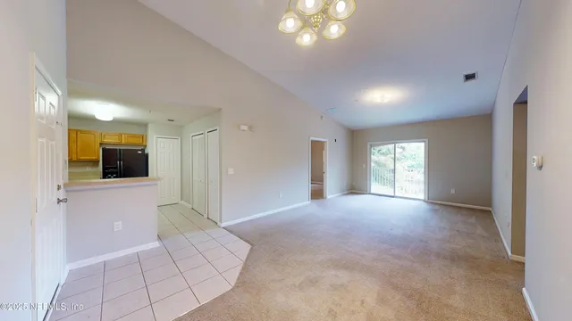 a view of a big room with windows and chandelier