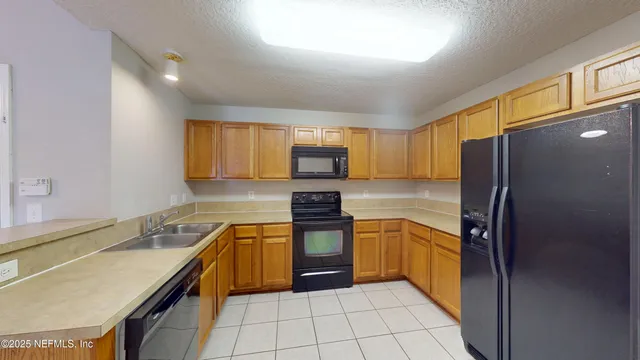 a kitchen with stainless steel appliances granite countertop a refrigerator sink and stove
