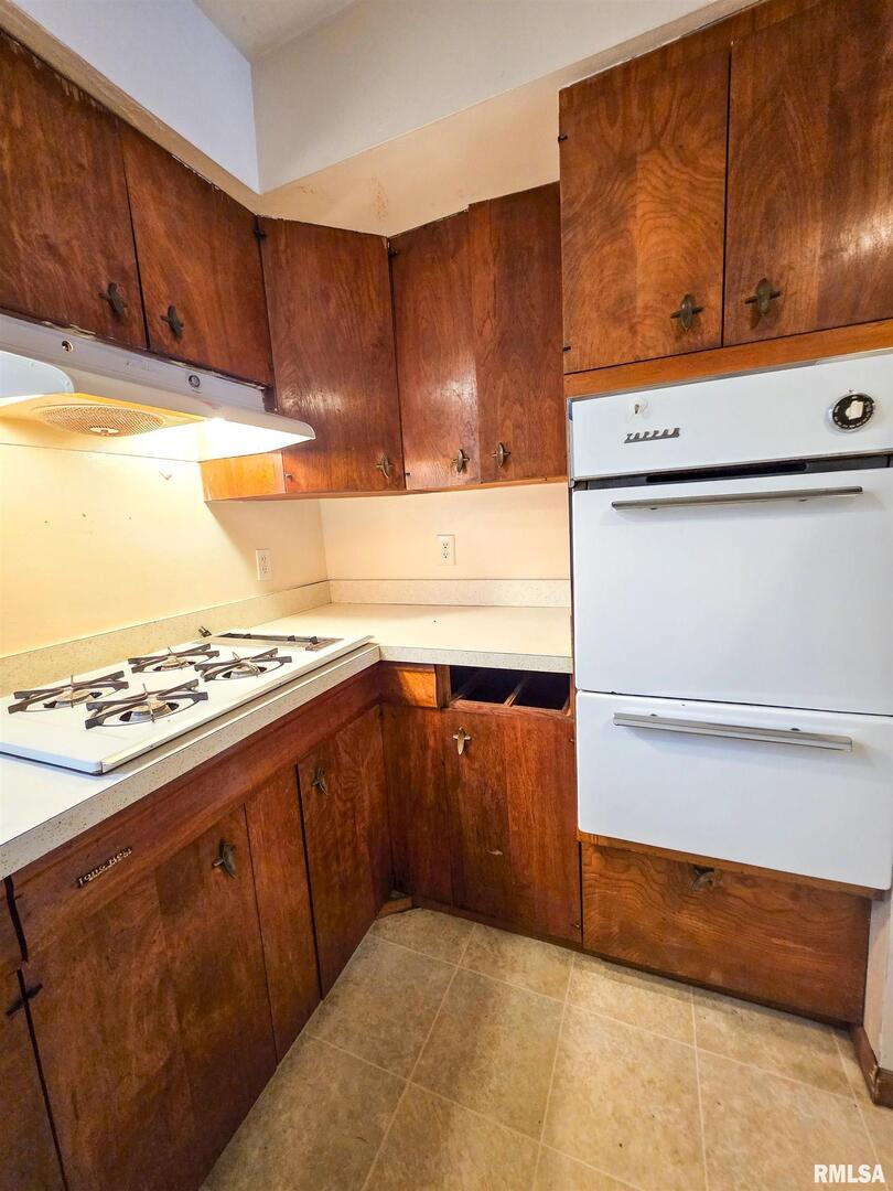 103 Watkins Street Cisne, IL 62823 - Photo 47 of 85 a kitchen with wooden cabinets and a stove top oven