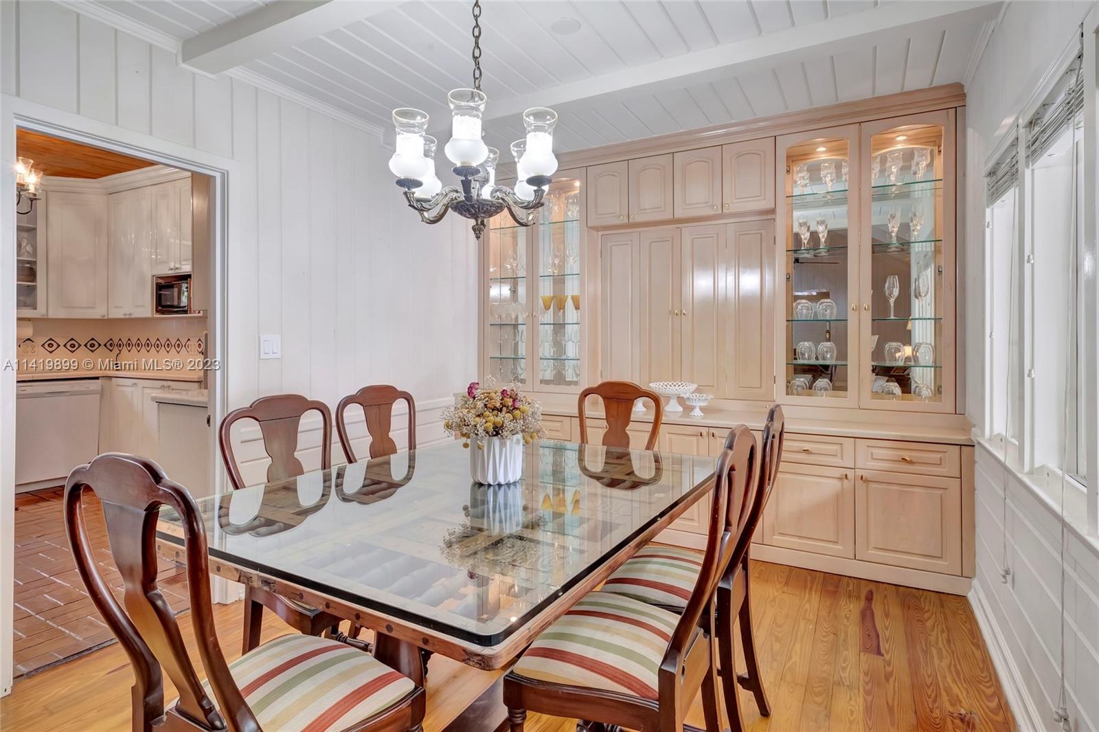 2801 Emathla Street Miami, FL 33133 - Photo 9 of 16 a dining room with furniture a chandelier and wooden floor
