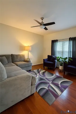 a living room with furniture and a wooden floor