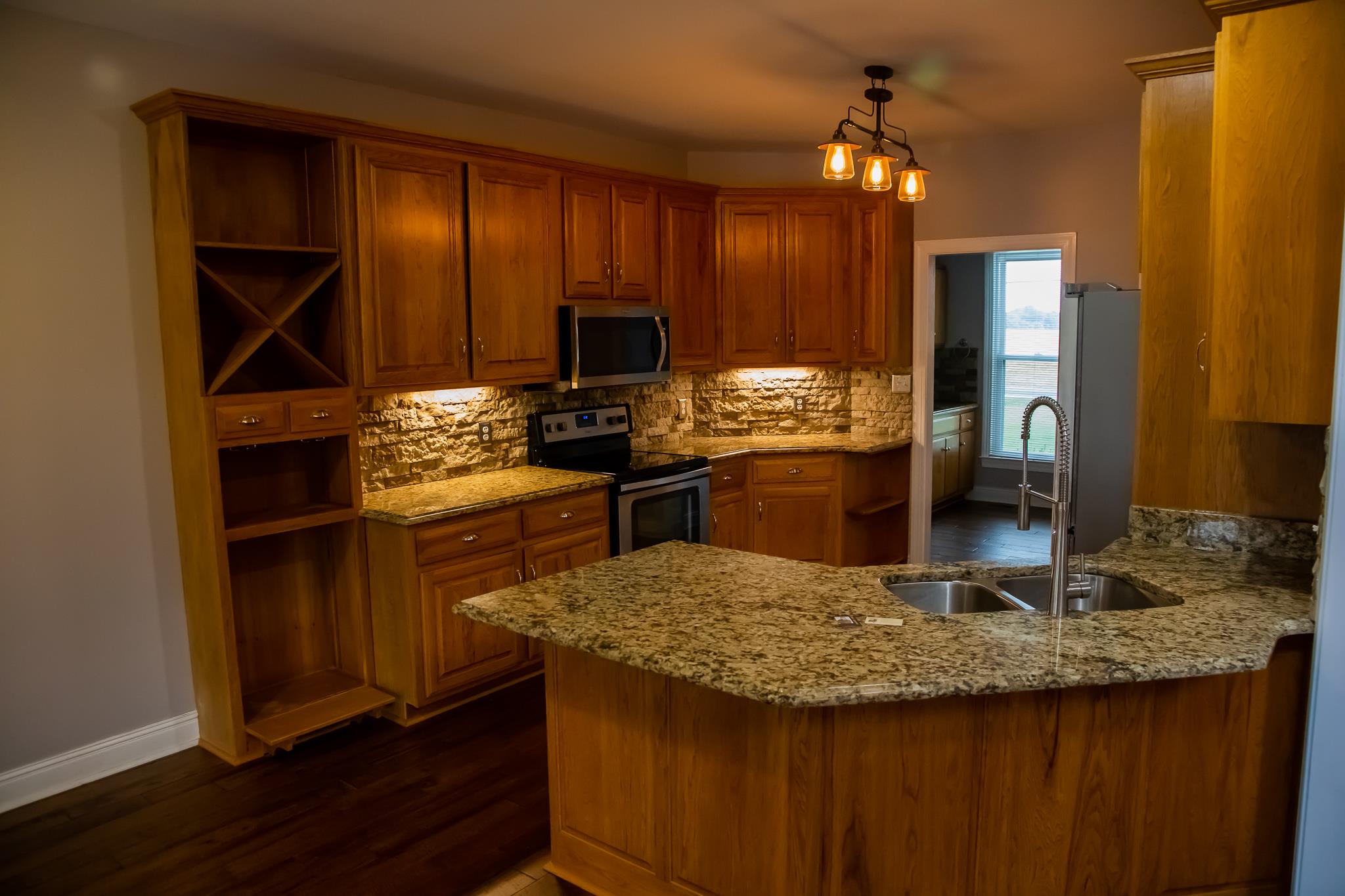 4871 Sango Road Clarksville, TN 37043 - Photo 16 of 30 a kitchen with kitchen island granite countertop wooden cabinets and a counter top space