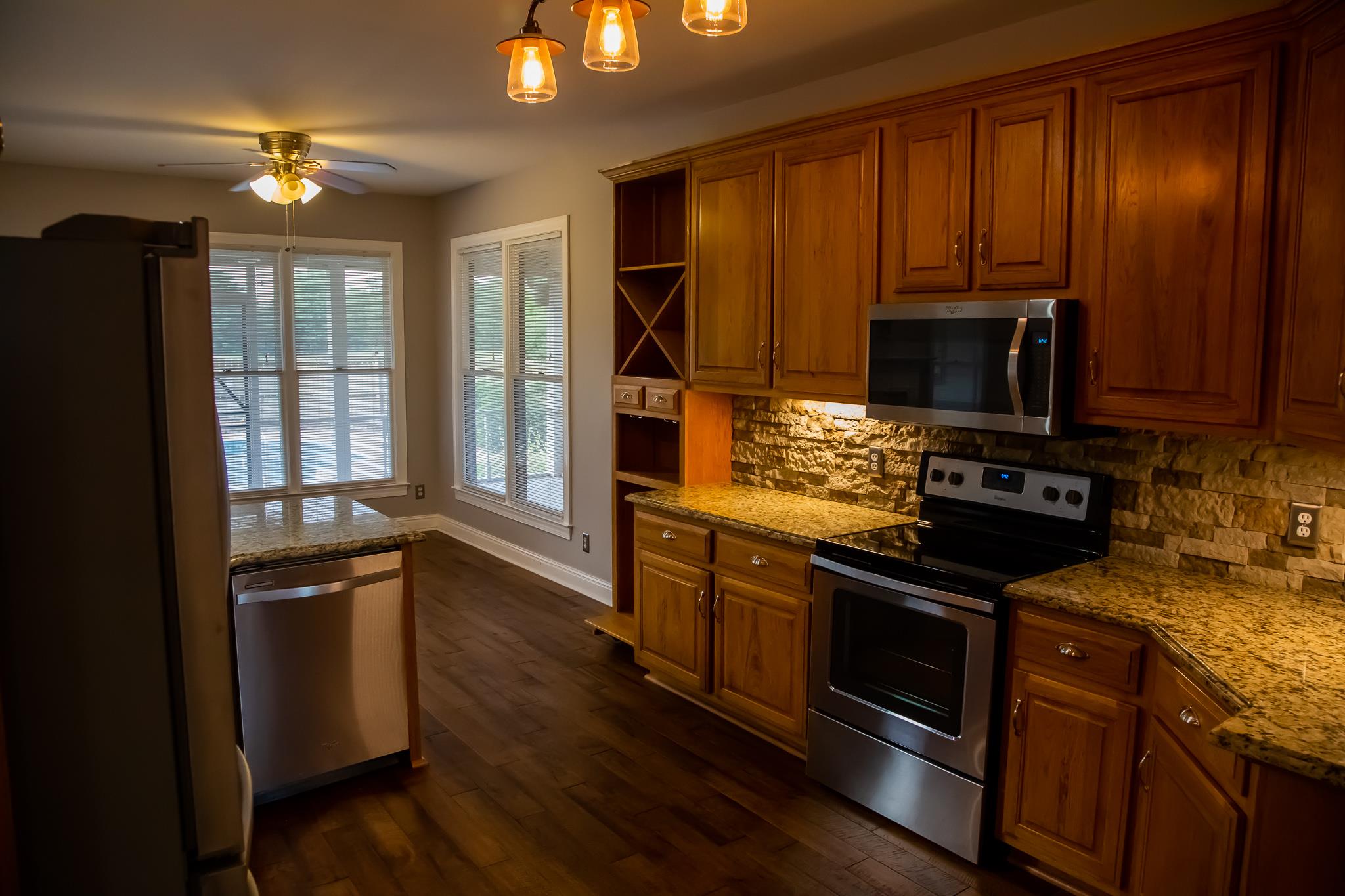 4871 Sango Road Clarksville, TN 37043 - Photo 17 of 30 a kitchen with granite countertop wooden cabinets stainless steel appliances and a window
