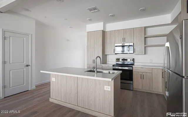 a kitchen with kitchen island white cabinets and stainless steel appliances