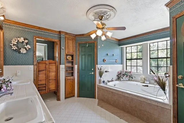 a spacious bathroom with a tub sink and mirror
