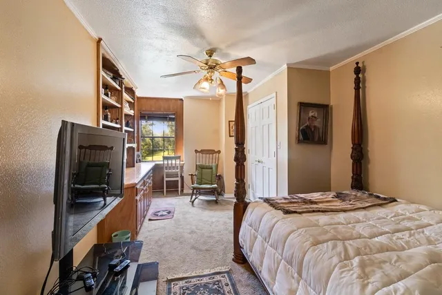 a bedroom with a bed and a flat tv screen on the dresser