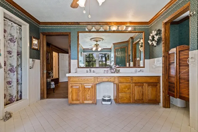 a view of living room kitchen with stainless steel appliances wooden floor and chandelier