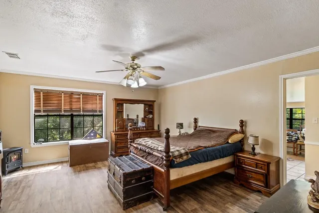 a bedroom with a large bed a chandelier and windows