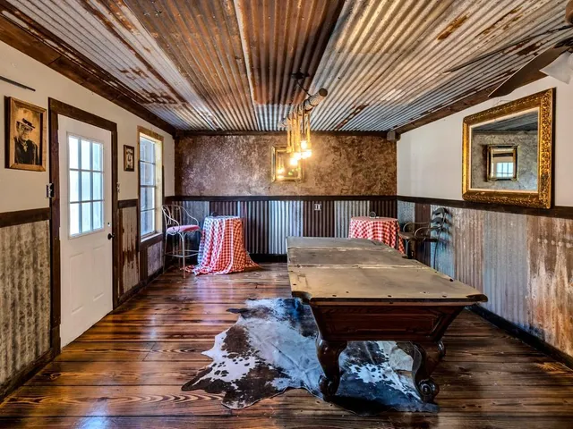 a living room with furniture stairs and a large window